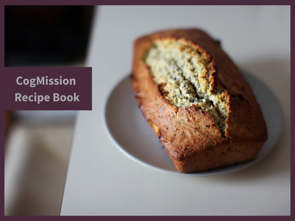 Golden loaf of poppy seed banana bread on a white plate, with "CogMission Recipe Book" label